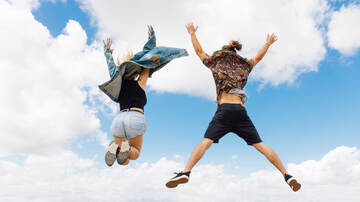 Zwei Menschen springen hoch vor Freude